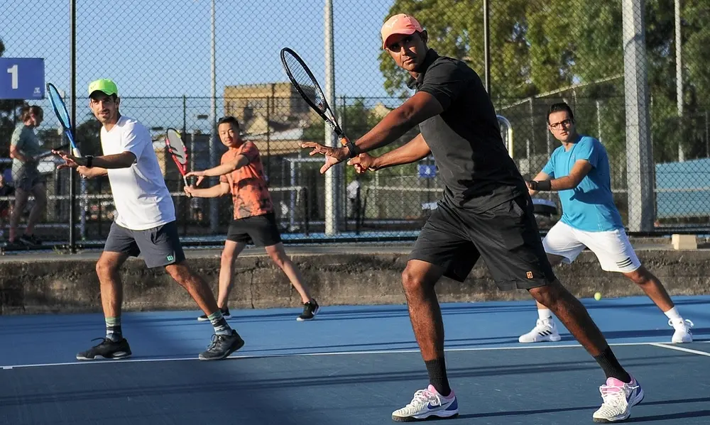 Hero — coaching group hitting forehands on the Parkville courts at golden hour