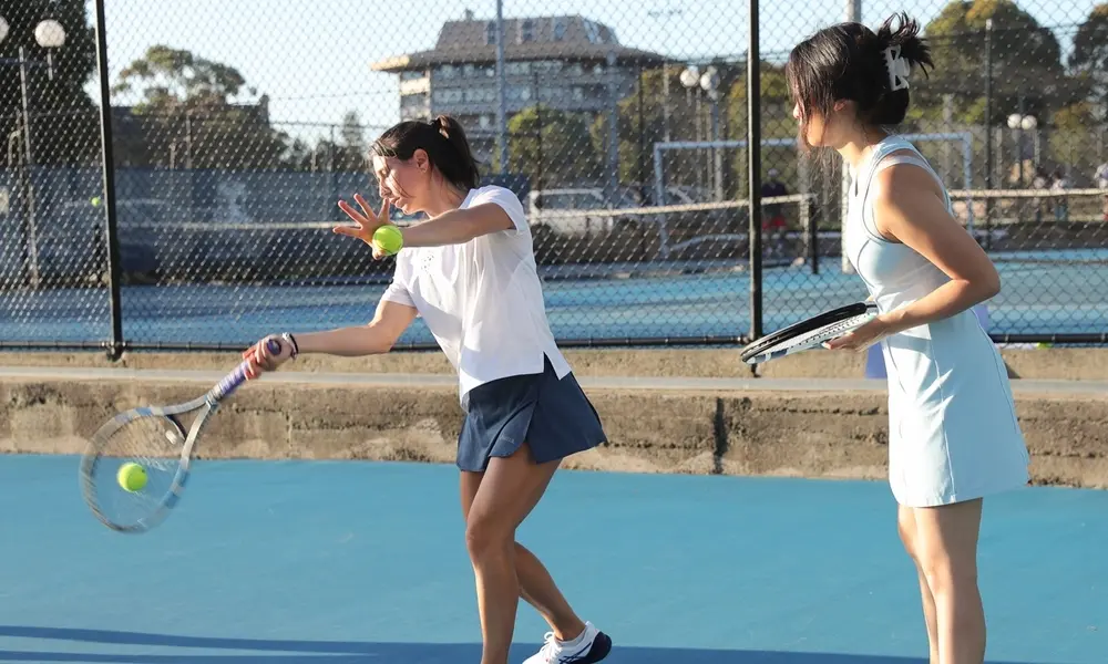 Social play — two players rallying in the afternoon sun