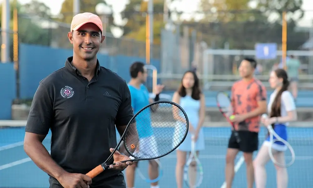 Head coach on court with a group of adult players behind him